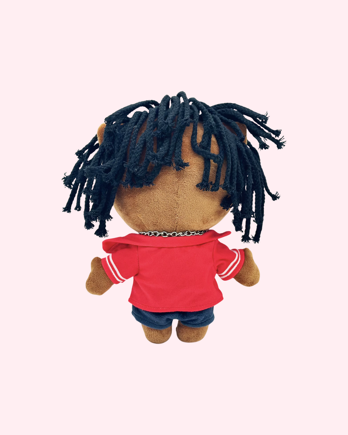 Back view of 21 Savage Hello Kitty plush showing black yarn hair and a red shirt on a pale pink background.