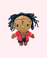 Front view of 21 Savage Hello Kitty plush with black yarn hair, a red shirt and dark shorts on a pale pink background.