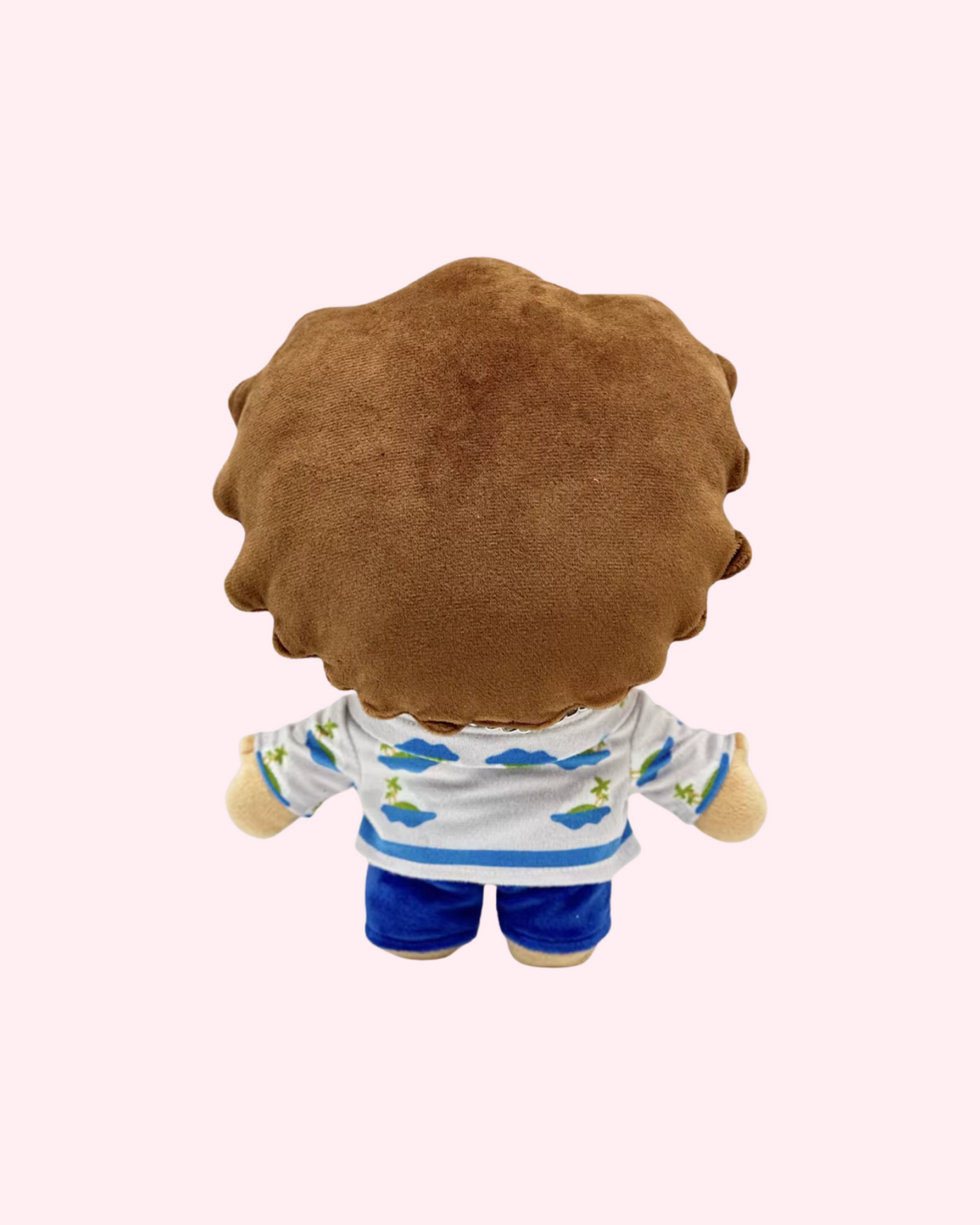 Back view of Bruno Mars Hello Kitty plush showing brown hair, a patterned shirt and blue shorts on a pale pink background.