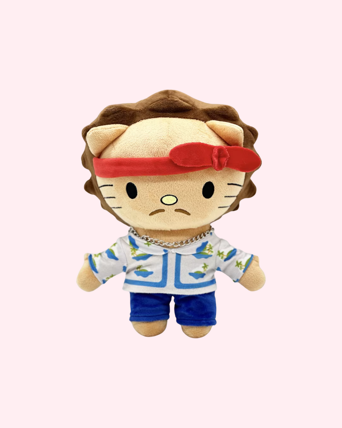 Front view of Bruno Mars Hello Kitty plush with a red headband, patterned shirt and blue shorts on a pale pink background.