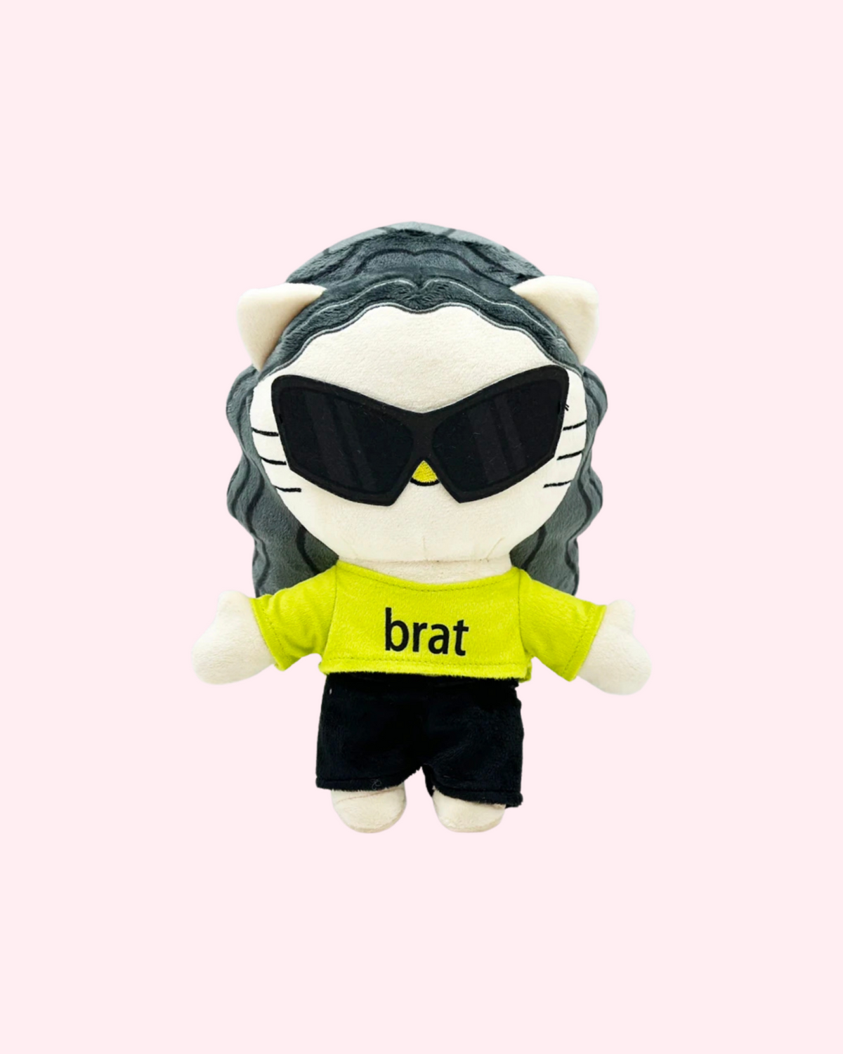 Front view of Charli xcx Hello Kitty plush with dark wavy hair, oversized sunglasses, a lime green brat shirt and black shorts, on a pale pink background.