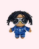 Front view of Chief Keef Hello Kitty plush with black yarn hair, oversized sunglasses and a blue outfit on a pale pink background.