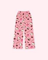 Front view of pink Hello Kitty pajama pants with lipstick tubes, bows, hearts and eye-mask motifs
