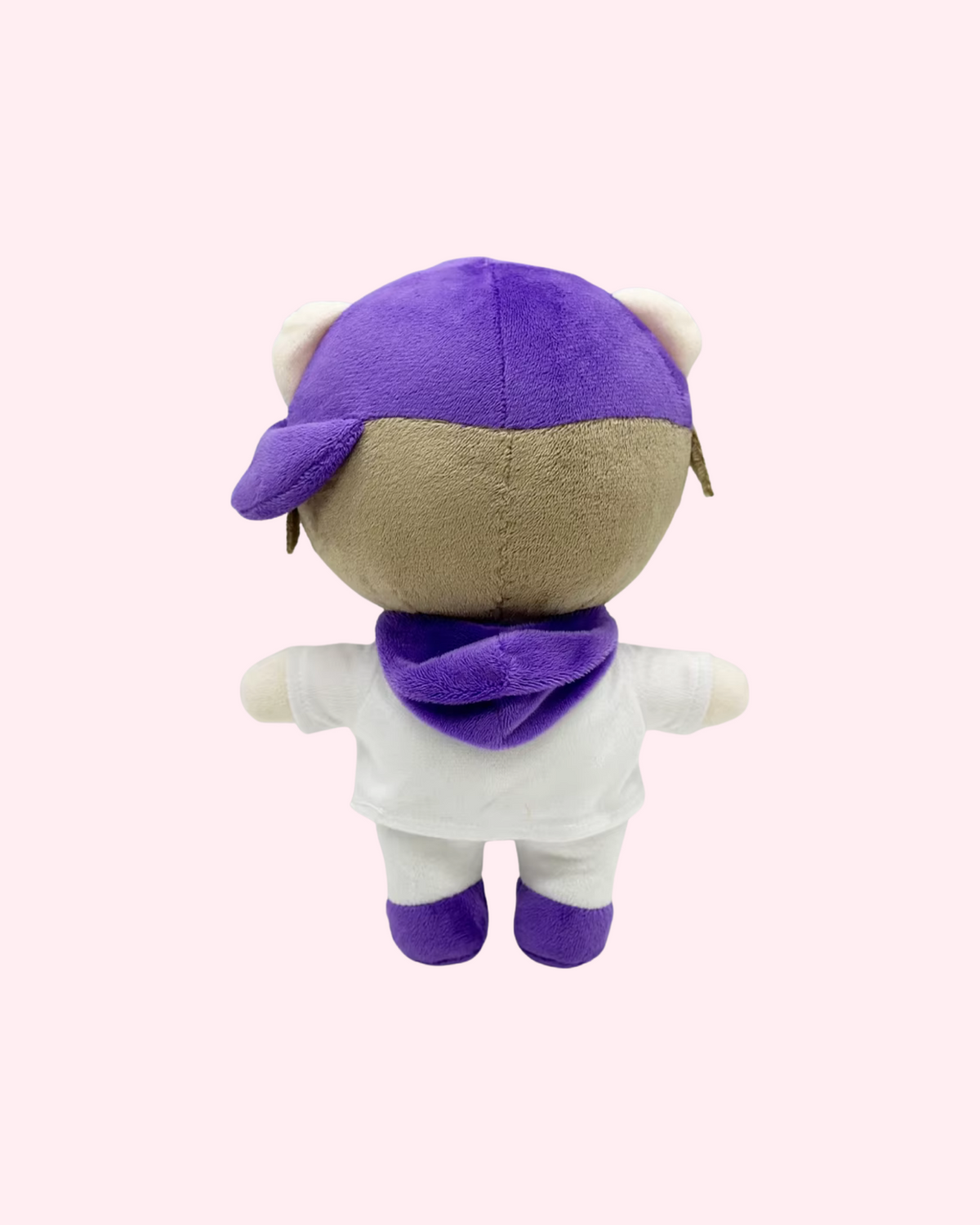 Back view of Justin Bieber Hello Kitty plush with a purple cap, a purple collar and a white-and-purple outfit, on a pale pink background.