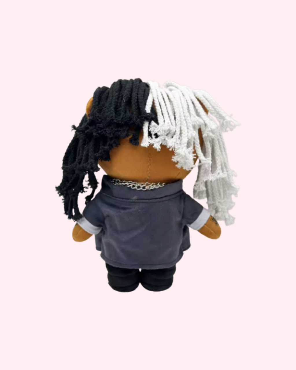 Back view of Ken Carson Hello Kitty plush showing black-and-white yarn hair and a dark jacket on a pale pink background.