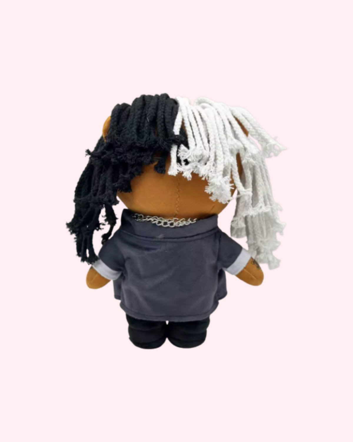 Back view of Ken Carson Hello Kitty plush showing black-and-white yarn hair and a dark jacket on a pale pink background.