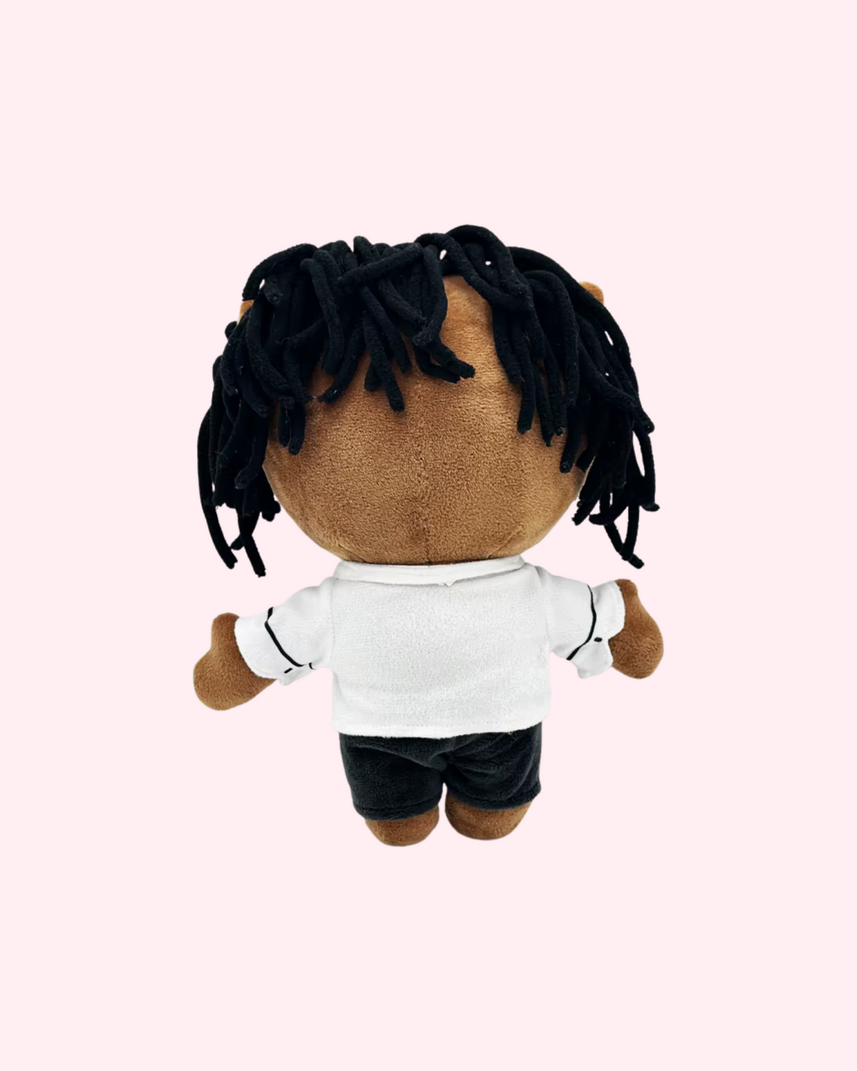 Back view of Kendrick Lamar Hello Kitty plush with dark yarn hair, a white shirt and black shorts, on a pale pink background.