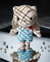 Lady Gaga Hello Kitty plush on a mirrored surface with scattered clear crystals and patterned light.