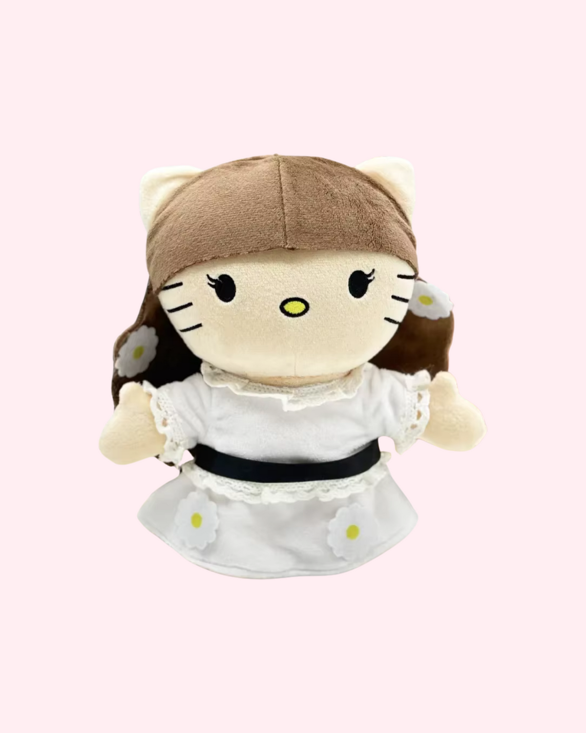 Front view of Lana Del Rey Hello Kitty plush with brown hair with daisies and a white lace-trimmed dress with a black waist belt, on a pale pink background.