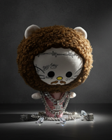Post Malone Hello Kitty plush in a pink outfit under a spotlight with silver-tone chains.