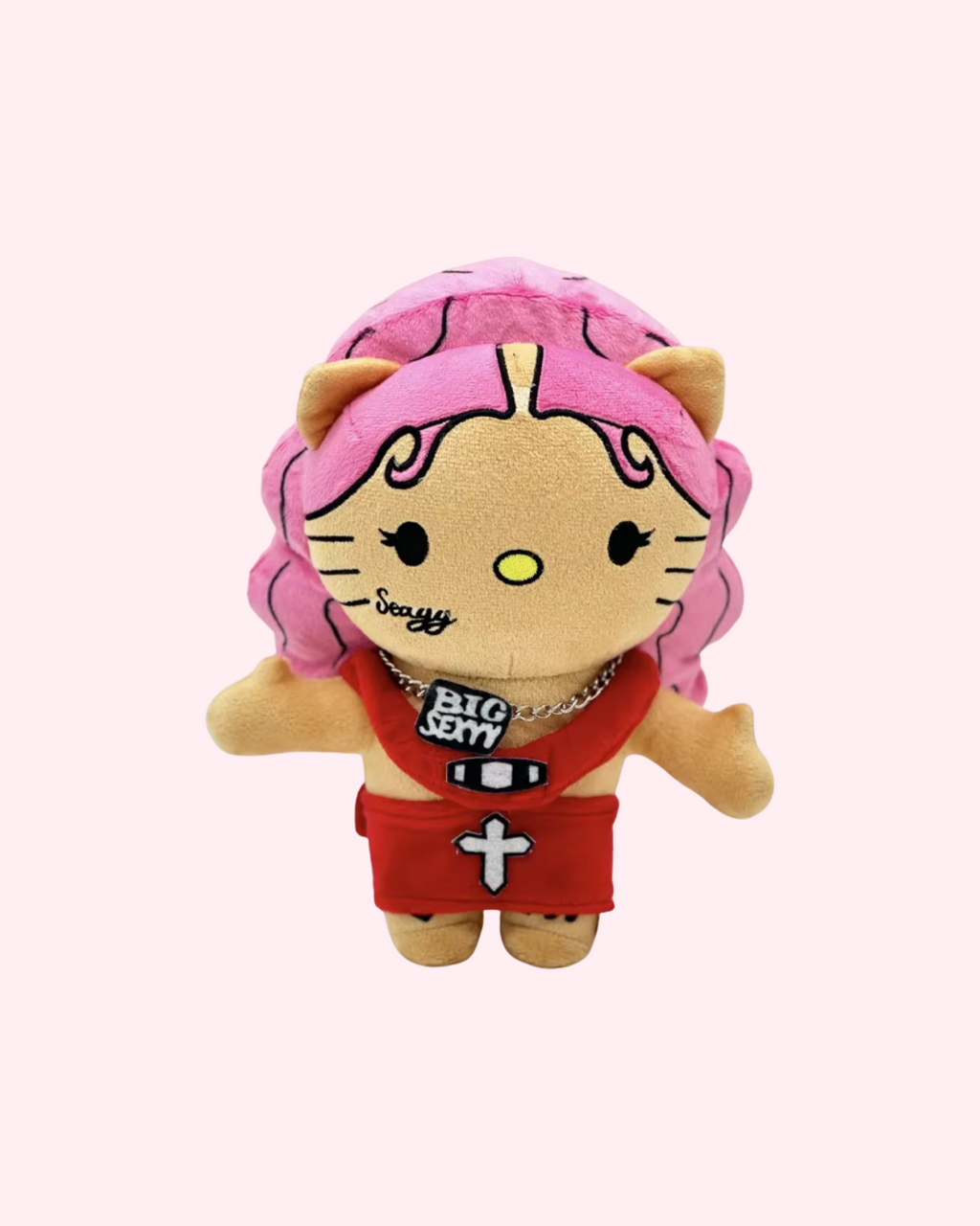 Front view of Sexyy Red Hello Kitty plush with pink hair, a red outfit and statement pendant details on a pale pink background.