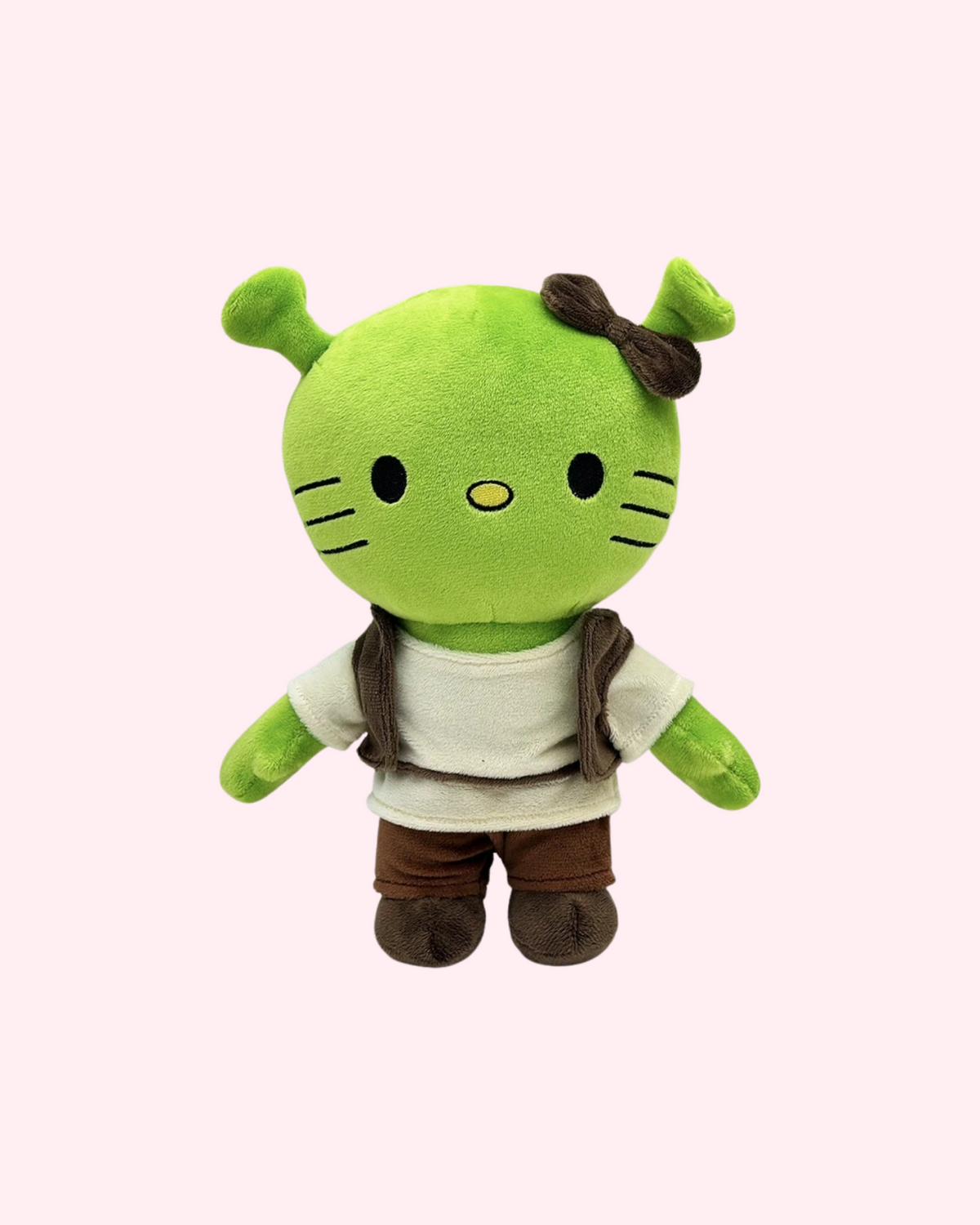 Front view of Shrek Hello Kitty plush with green ogre ears, a cream tunic, brown vest and brown trousers, on a pale pink background.