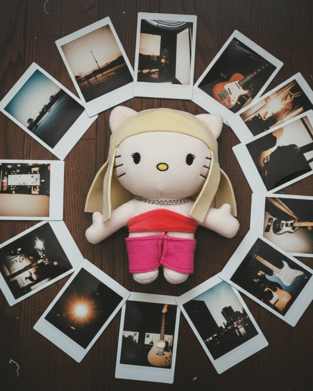 Taylor Swift Hello Kitty plush surrounded by instant photographs on a wooden surface.