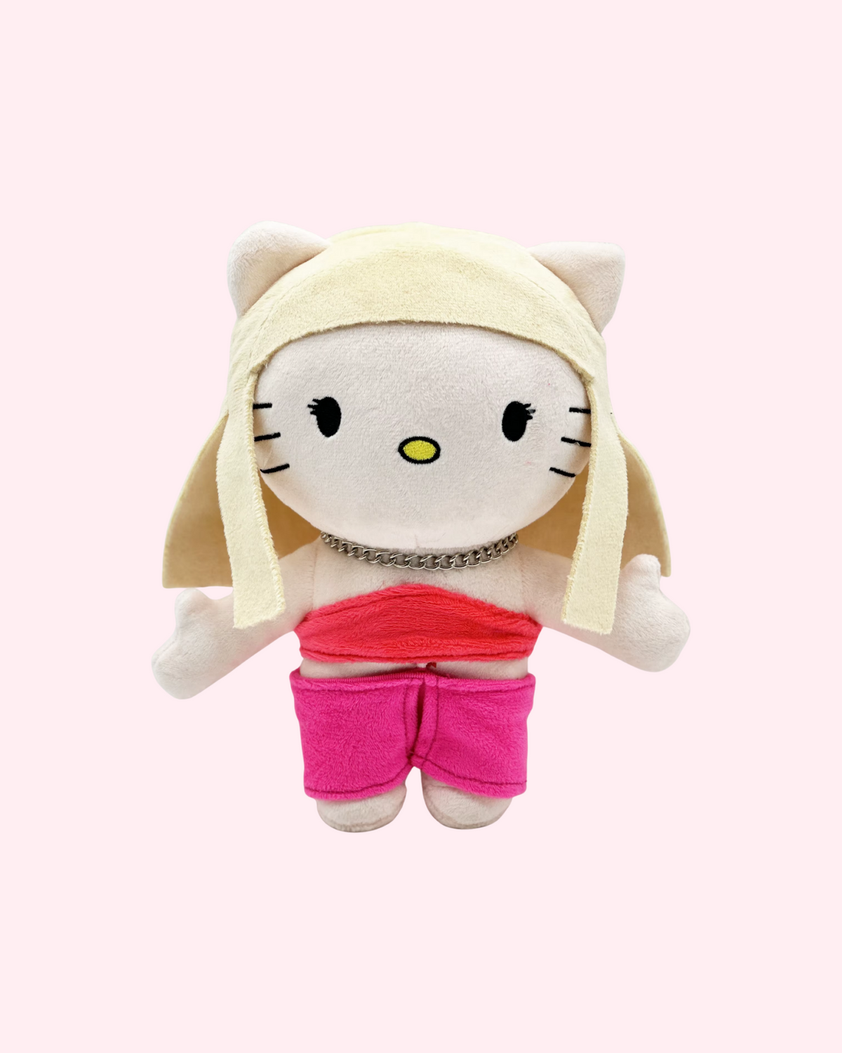 Front view of Taylor Swift Hello Kitty plush with blonde hair, a red top and pink shorts on a pale pink background.
